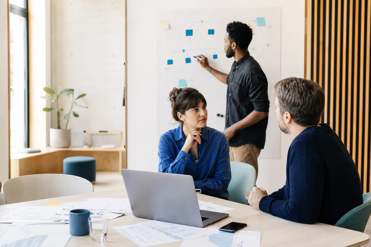 Une équipe échange autour d’un schéma de travail dans un atelier